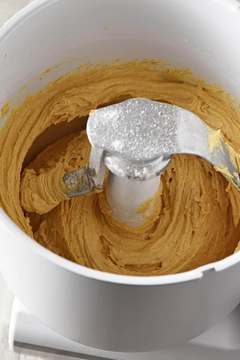 mixing pumpkin sugar cookie dough in white mixer
