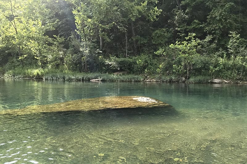 boulder sticking up out of the water on the Lower Jacks Fork River in Missouri