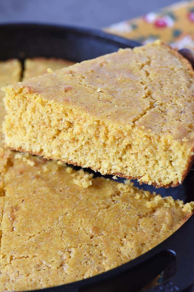 slicing buttermilk cornbread in cast iron skillet
