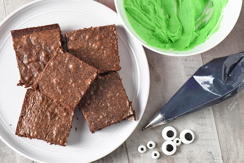 Frankenstein brownie ingredients, including brownie mix brownies, green icing, black icing, and candy eyeballs