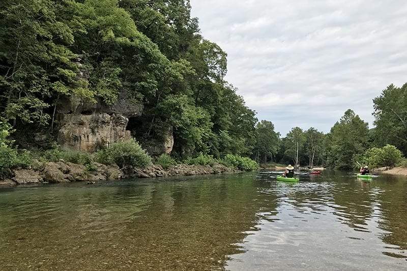 kayaking past a bluff on the Jacks Fork River