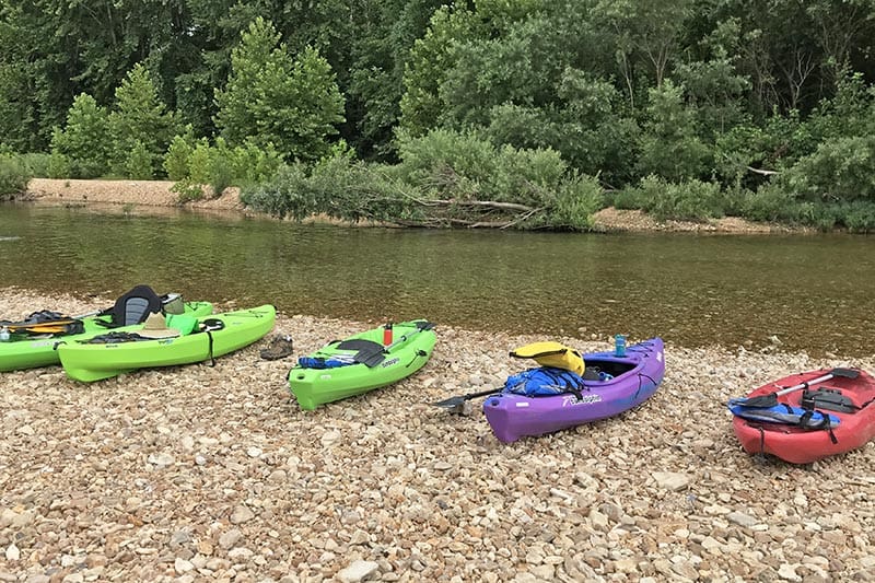 kayaks getting ready to launch on the banks of the Jacks Fork River at the Burr Oak day use area at Alley Spring