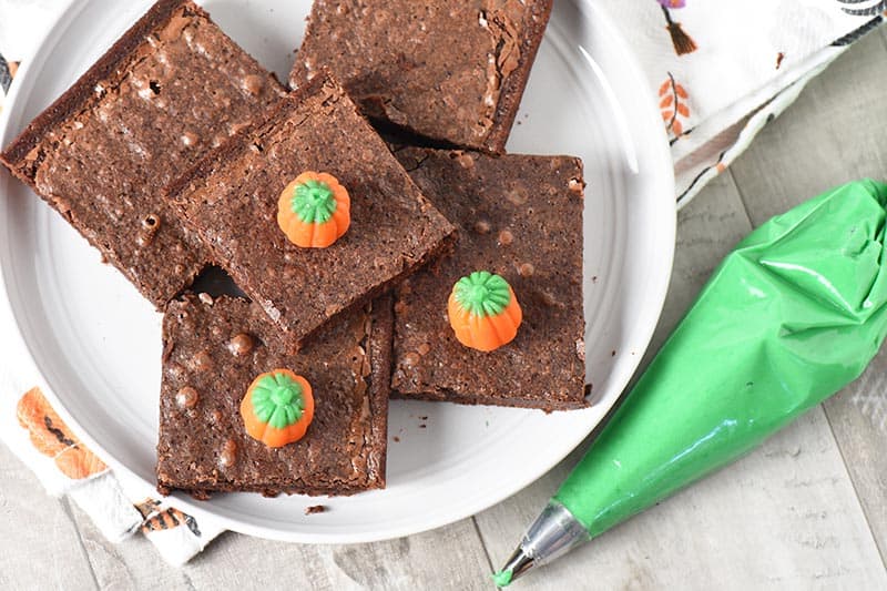 ingredients for pumpkin patch halloween brownies, including brownies, green icing, and Brach's mellowcreme pumpkins