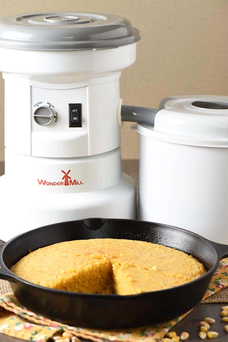 WonderMill grain mill with homemade buttermilk cornbread baked in cast iron skillet