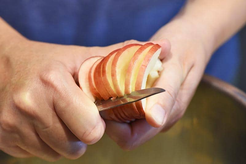 slicing apples while making cinnamon applesauce