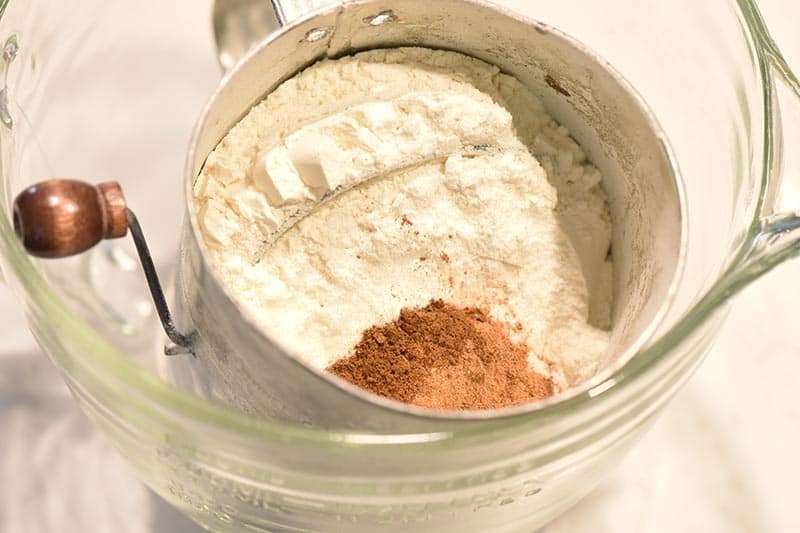 sifting dry ingredients for pumpkin bread recipe