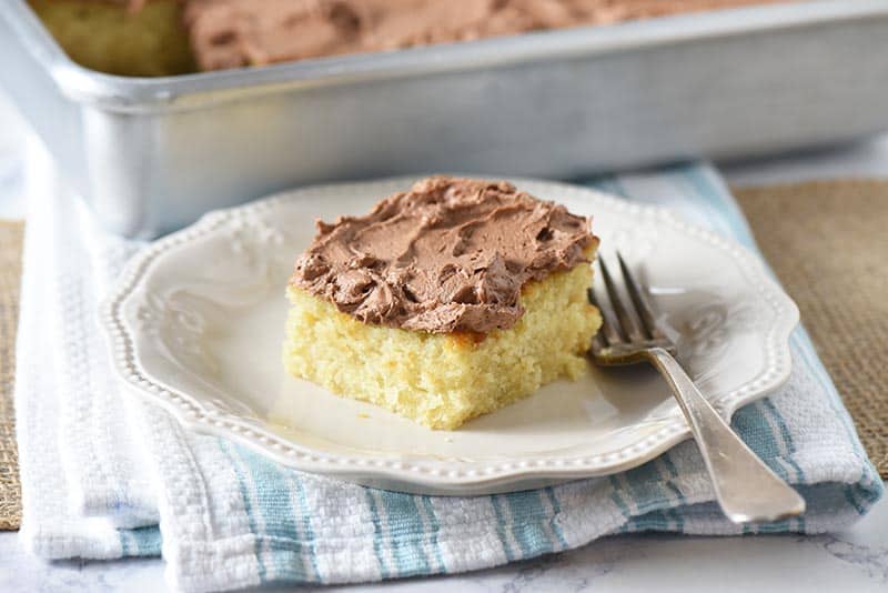 slice of fluffy, moist yellow cake on white plate with fork