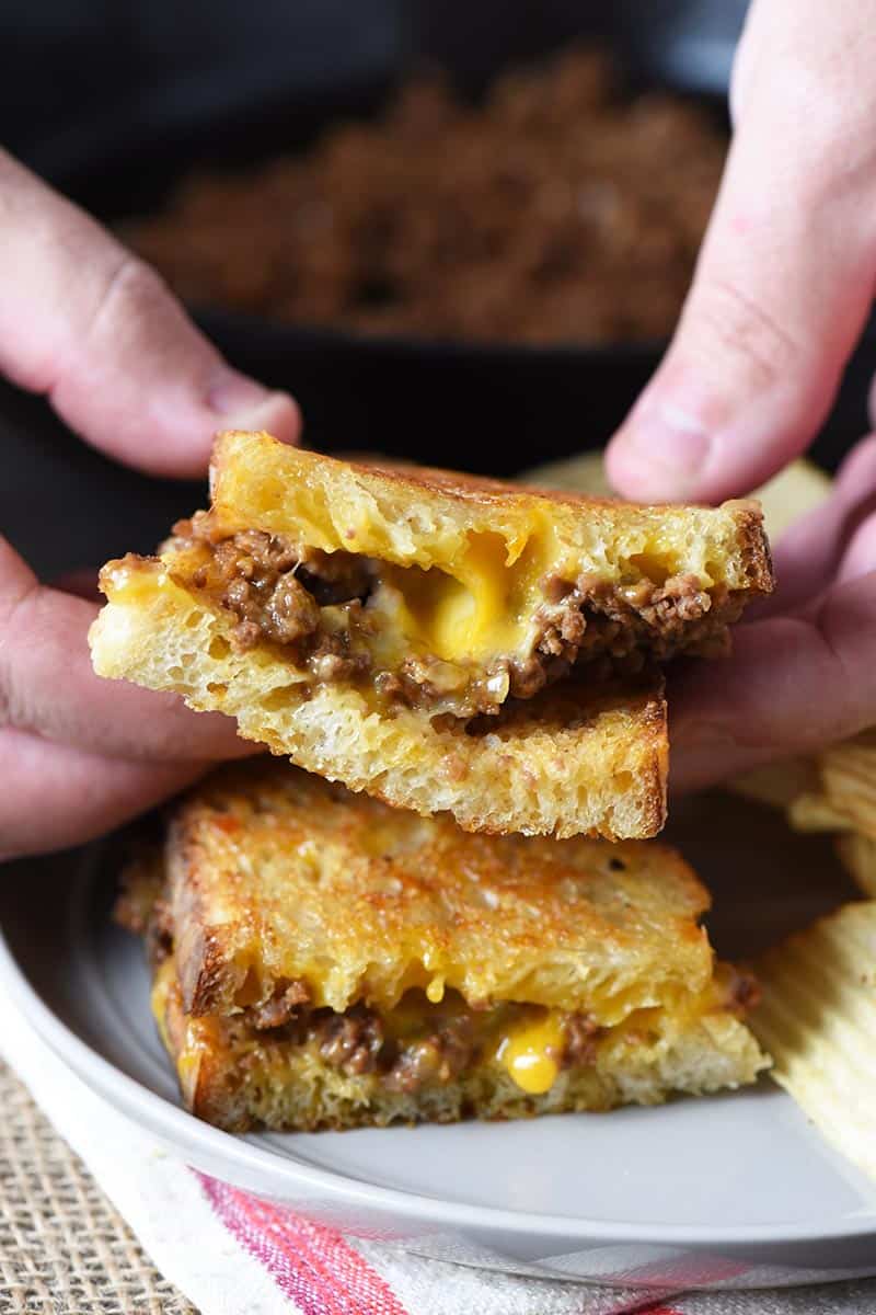 holding grilled cheese sandwich sloppy joes in hands