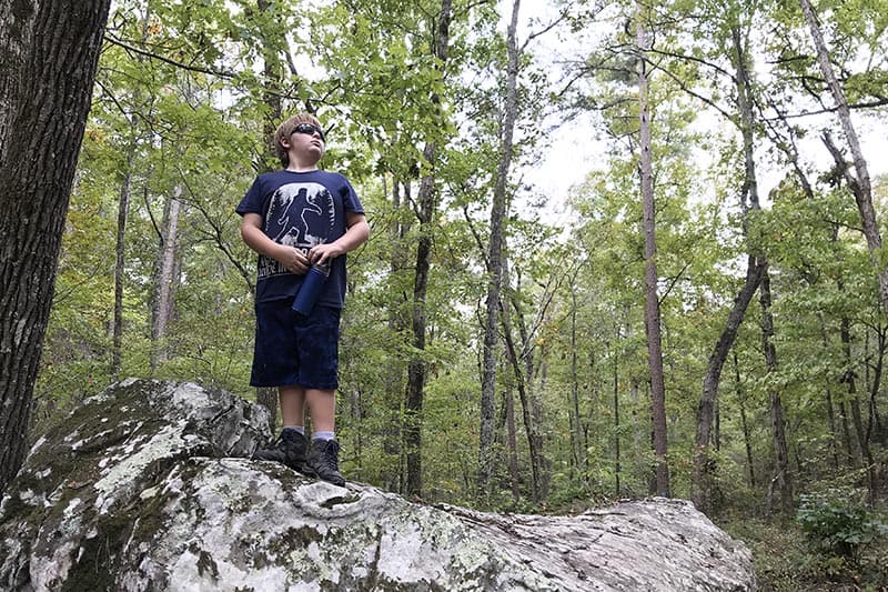 boy on boulder on Seven Hollows Trail in Petit Jean State Park in Arkansas