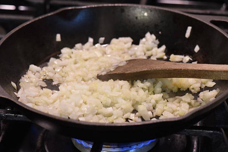 saute onions and garlic for grilled cheese sloppy joe recipe in iron skillet