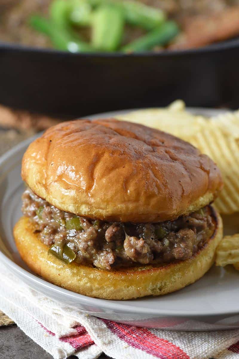closed face Philly cheese steak sloppy joes with potato chips on gray plate
