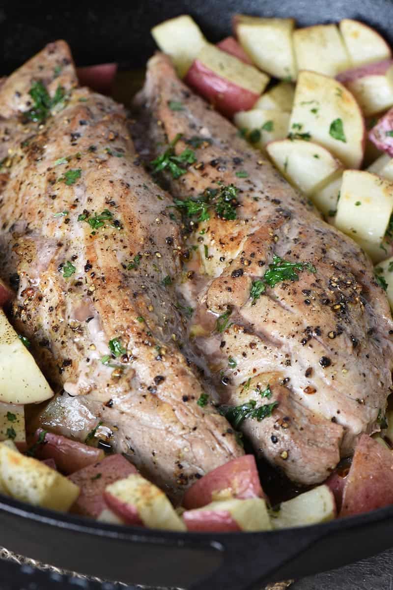 baked pork tenderloin and potatoes in cast iron skillet