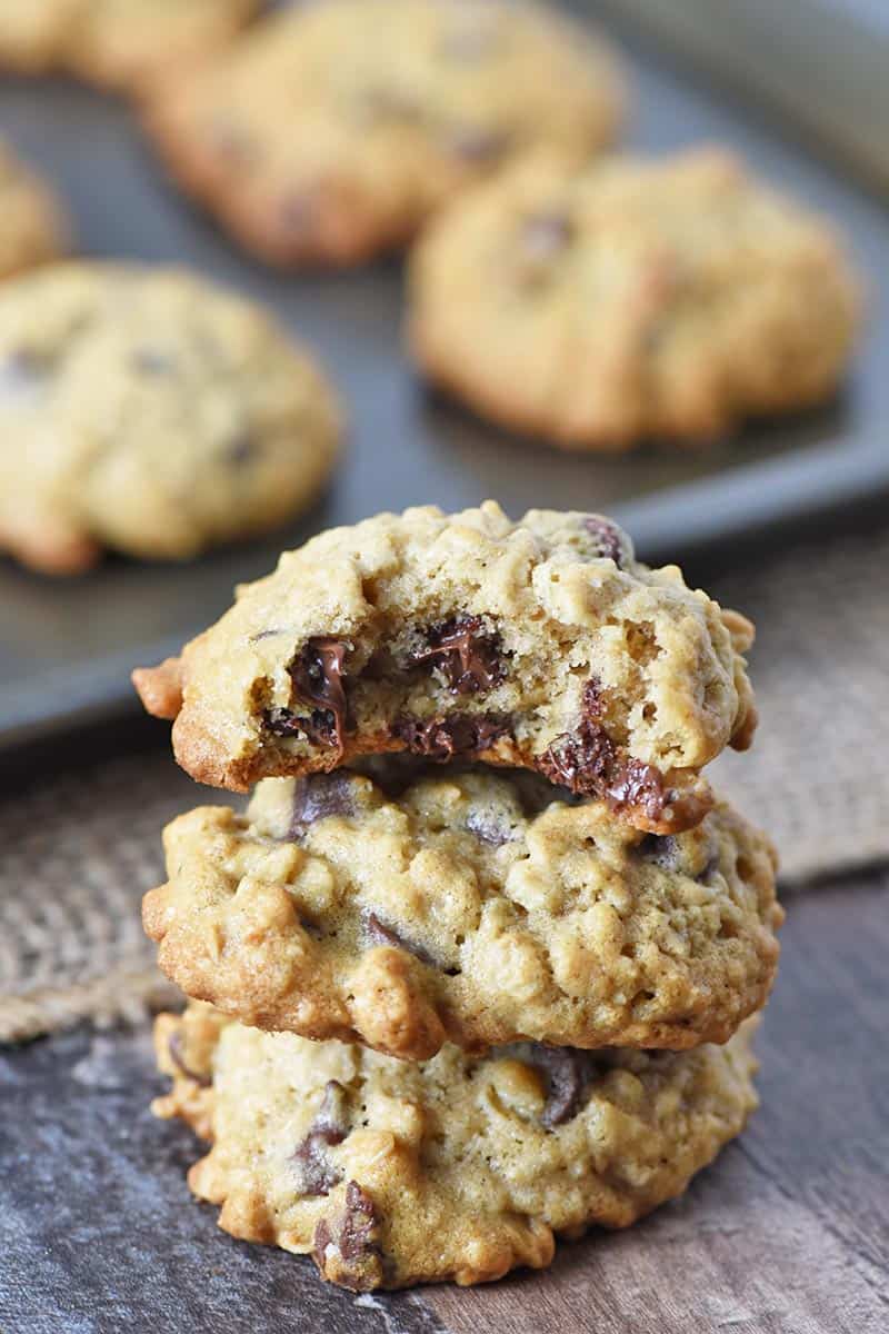 bite out of oatmeal chocolate chip cookie on stack of oatmeal cookies