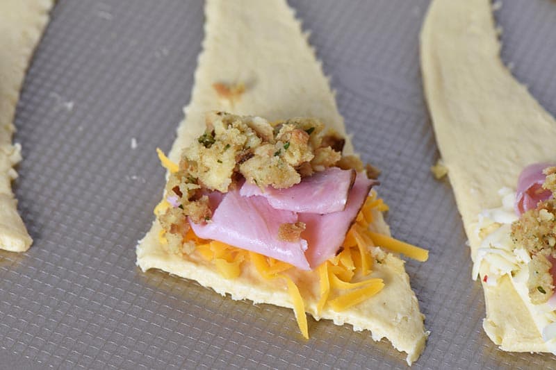 making leftover ham and stuffing crescent rolls on cookie sheet
