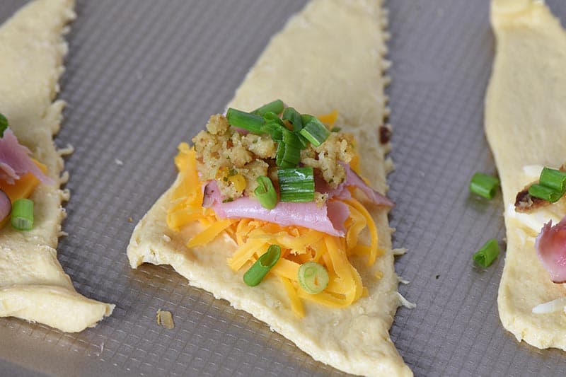 making leftover ham and stuffing crescent rolls with cheese, ham, stuffing, and green onions