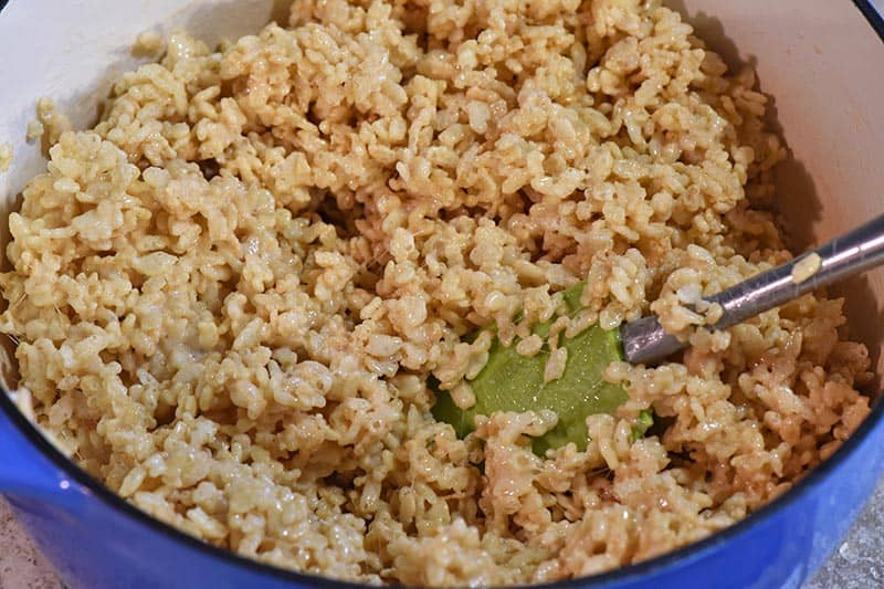 making Rice Krispies cereal into Rice Krispie treats in blue Dutch oven