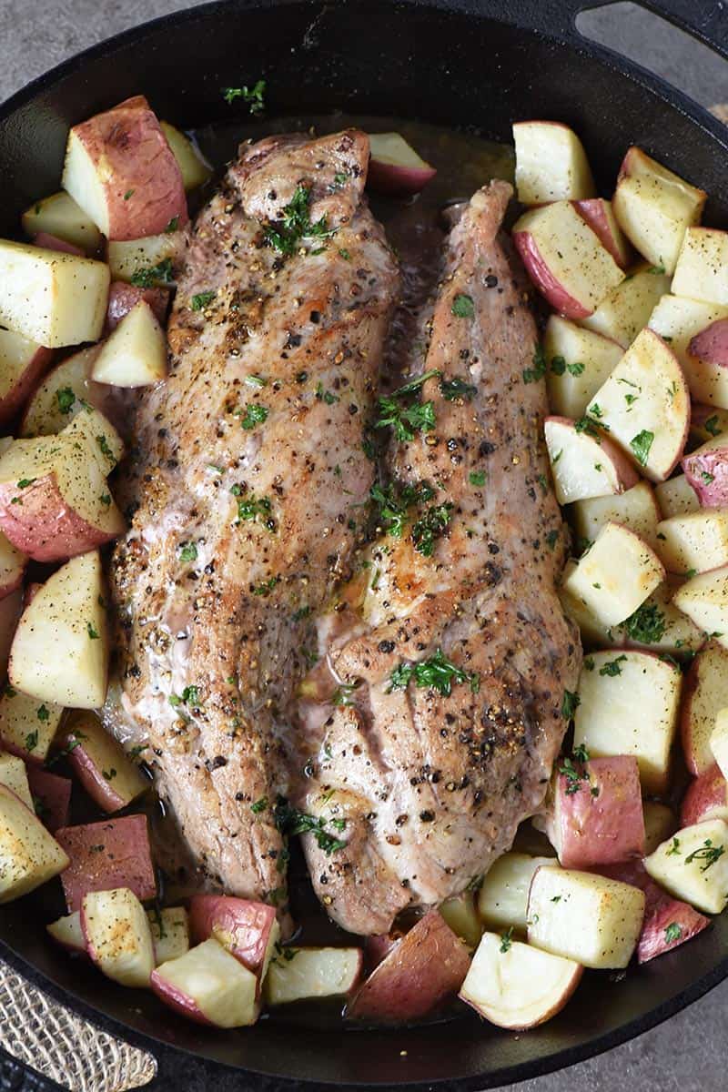 pork tenderloin with potatoes roasted in a cast iron skillet in the oven