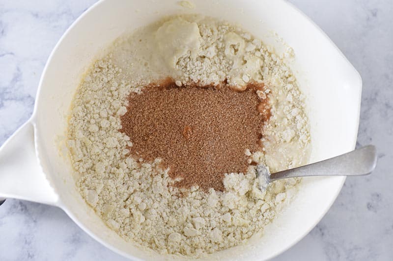 mixing cinnamon sugar into Bisquick sweet biscuit dough in white mixing bowl
