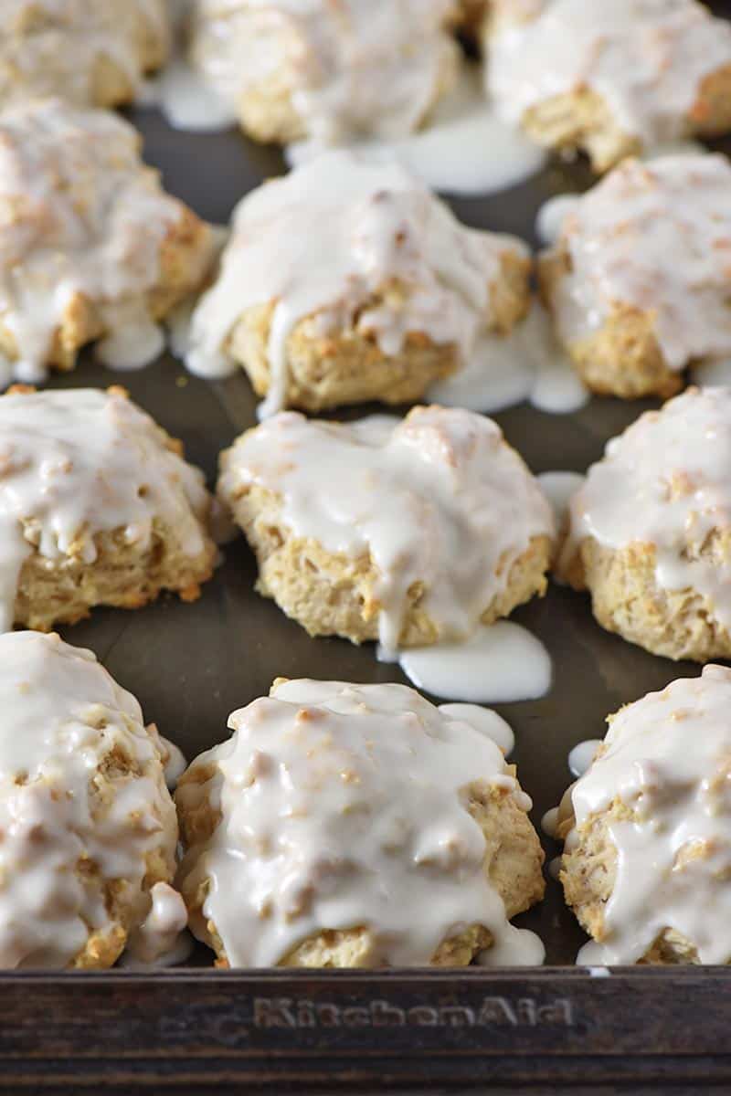 cinnamon sugar biscuits brushed with glaze on baking sheet