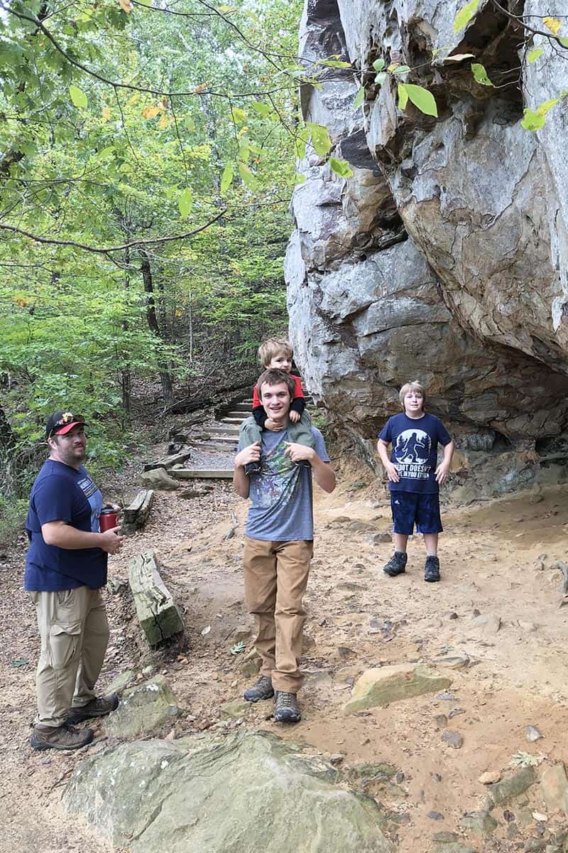 family with toddler hiking Bear Cave Trail, Arkansas hiking trail in Petit Jean State Park