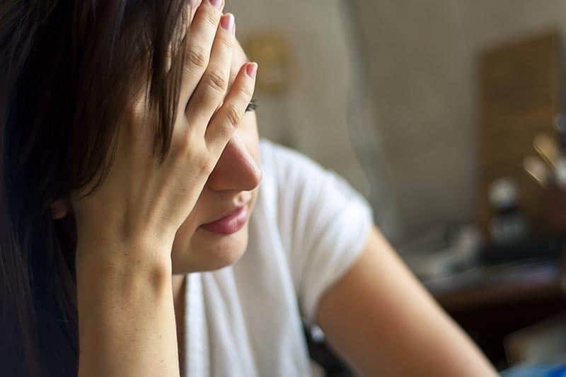 woman experiencing a headache, one of the Mirena crash symptoms