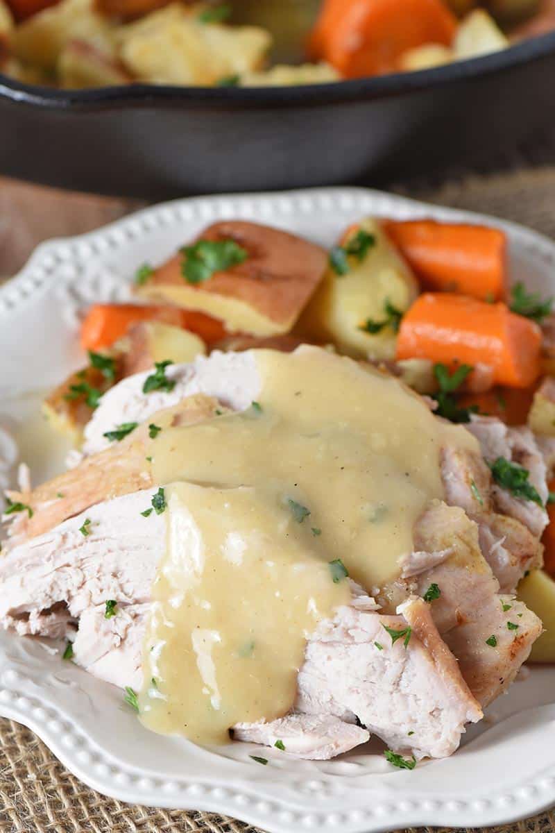 pork roast with vegetables and gravy on white plate