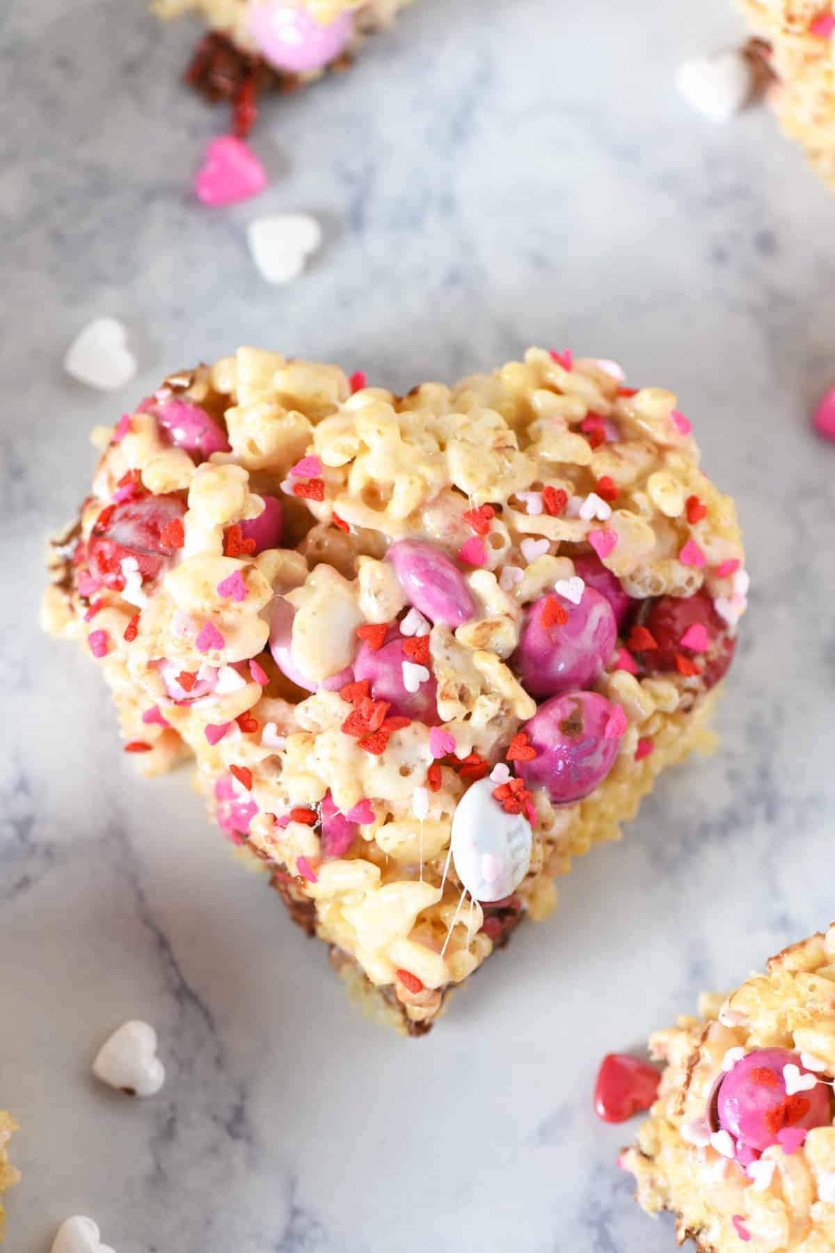 Valentine's Day heart shaped Rice Krispies treat with M&M's on white marble countertop