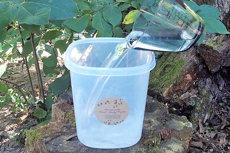 adding water to plastic canister for DIY body wipes for camping