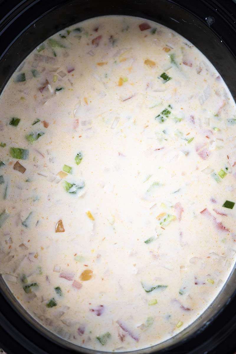 chicken enchilada soup ready to cook in black slow cooker crock