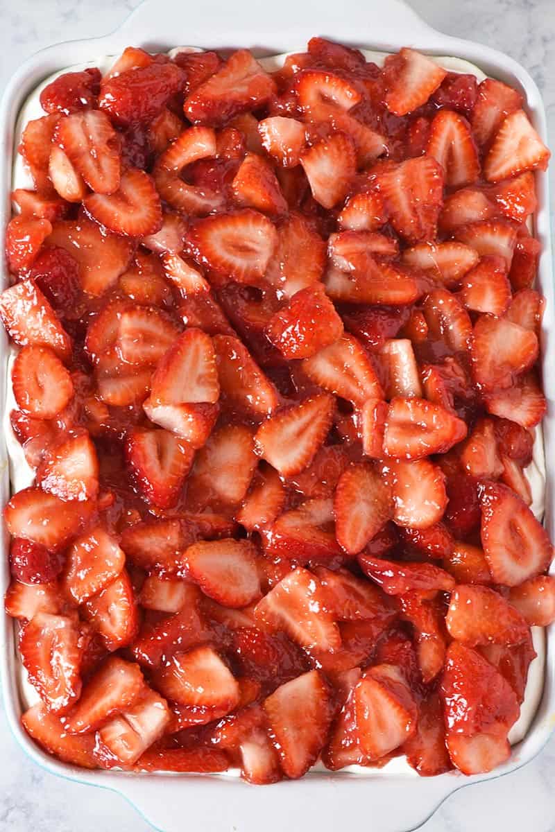 no bake strawberry delight dessert in blue and white baking dish, made with fresh strawberries