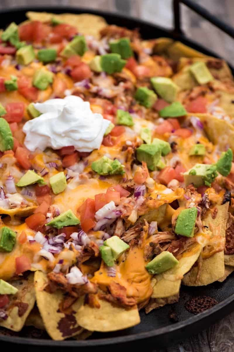 loaded chicken nachos in cast iron pan