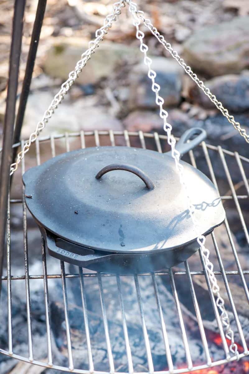 making campfire pizza over a campfire