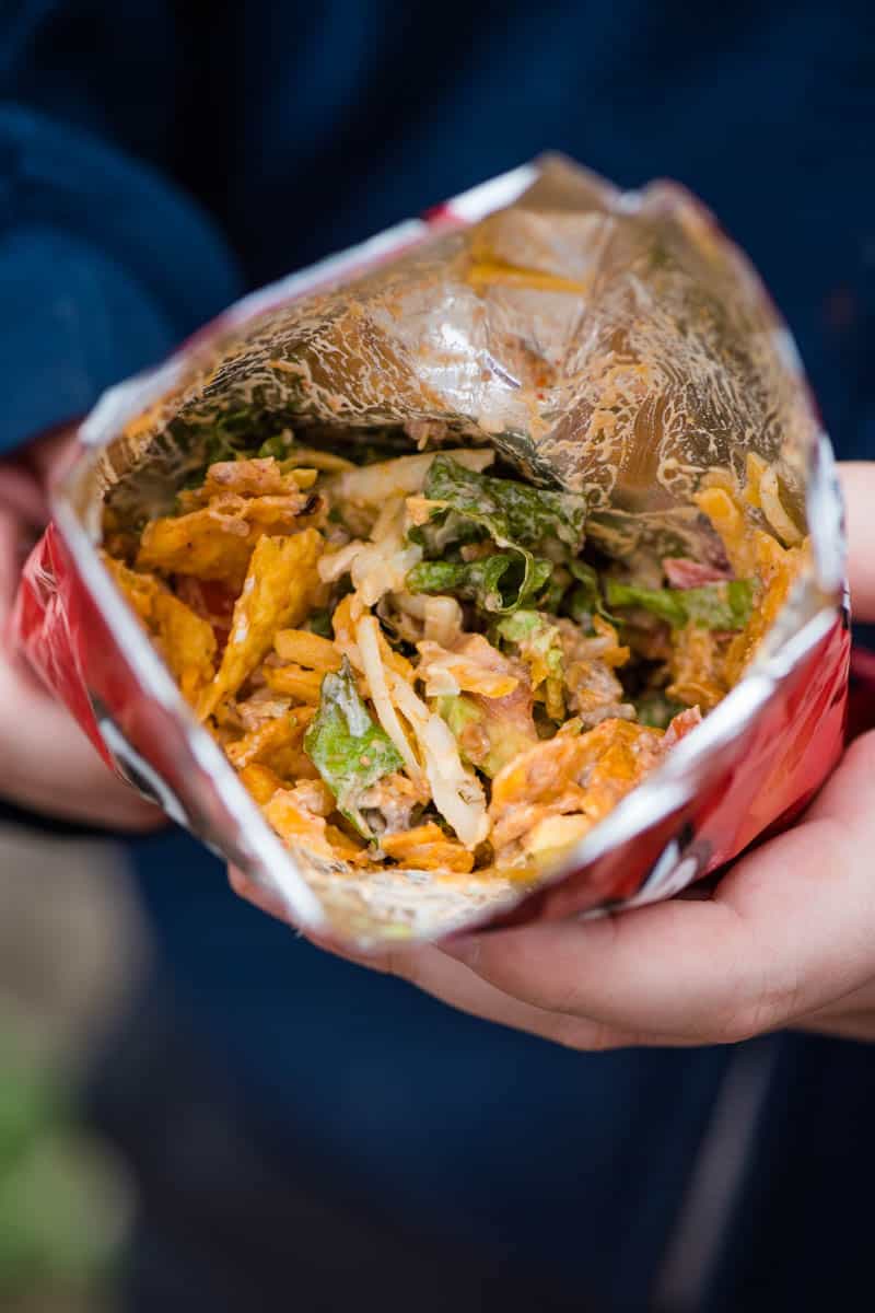 walking tacos camping recipe in a bag using individual size Doritos chip bag, ground beef, and taco toppings