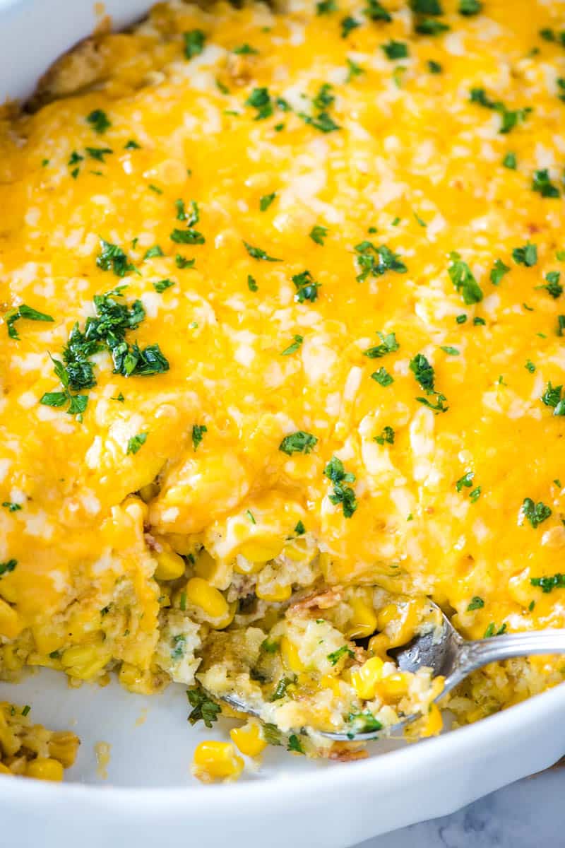 Jiffy corn pudding in white baking dish with serving spoon
