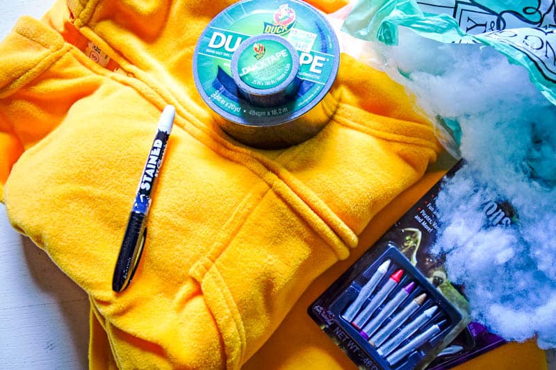 supplies to make a DIY Garfield costume, including orange pajamas, Duck Tape, quilt batting, a Sharpie fabric marker, and costume makeup