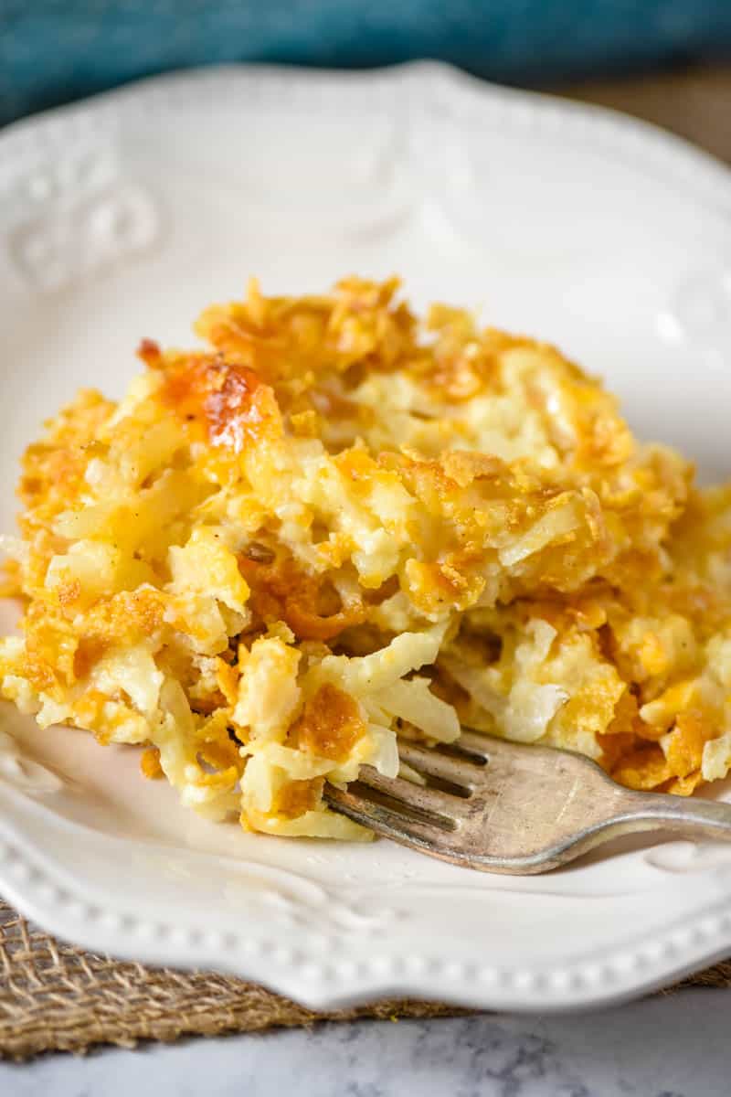 serving of hash brown casserole with Corn Flakes on white plate with fork