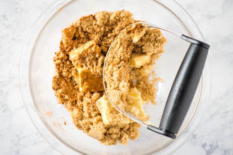 making topping for French toast bake in glass bowl with pastry blender
