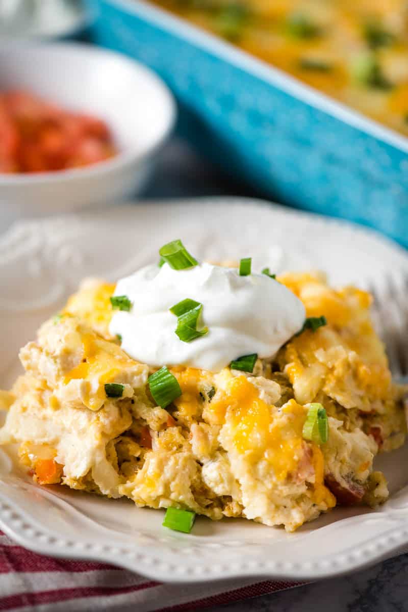 seafood enchiladas made with white crab meat served on white plate with sour cream and green onions