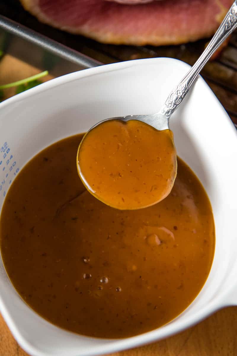 homemade ham gravy made with cornstarch in white Corning Ware dish with spoon