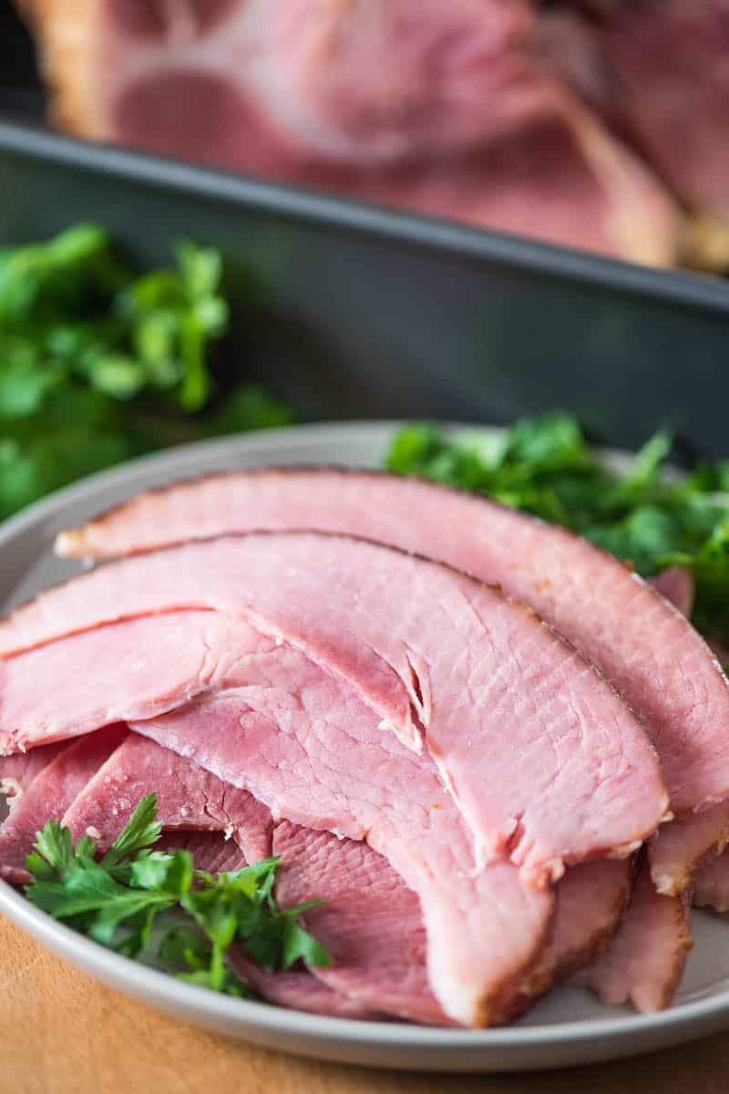 sliced ham on gray plate with Italian parsley