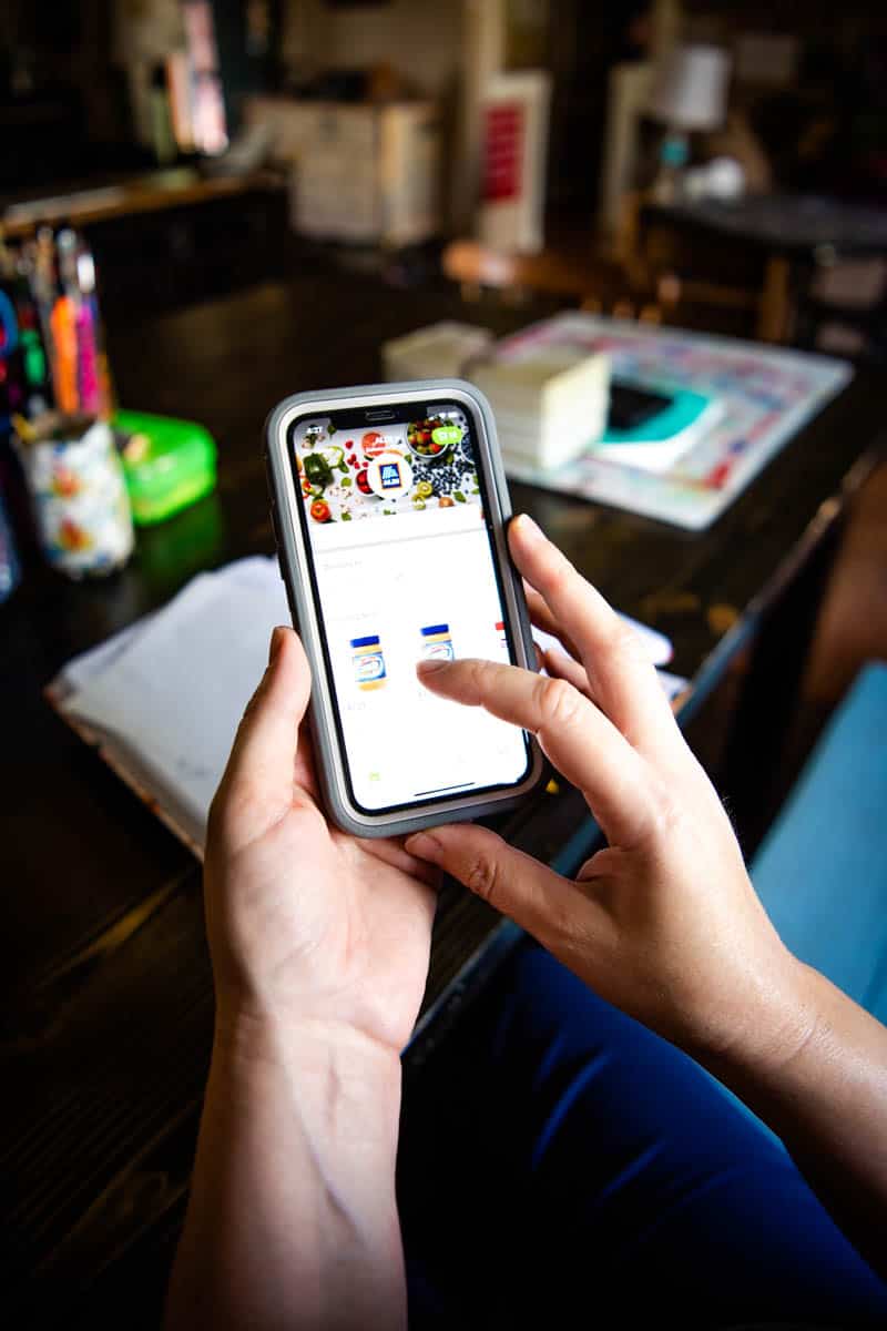 woman using iPhone app, Instacart, to order groceries online