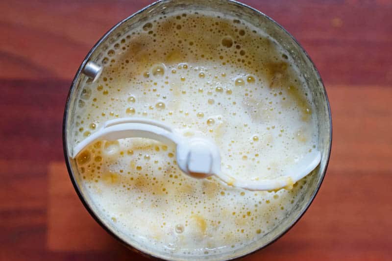 banana ice cream mixture before freezing in metal canister with white churn paddle