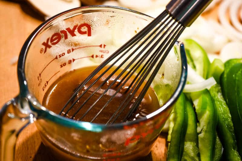 whisking beef broth with flour in glass Pyrex measuring cup