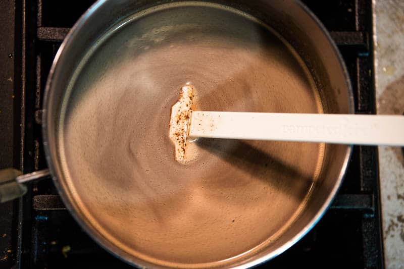 cooking homemade hot cocoa with chocolate chips in saucepan on stove