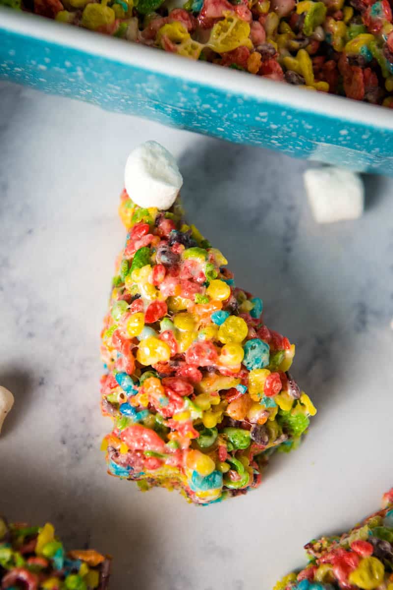 Christmas Fruity Pebble marshmallow treat on white marble countertop with mini marshmallows