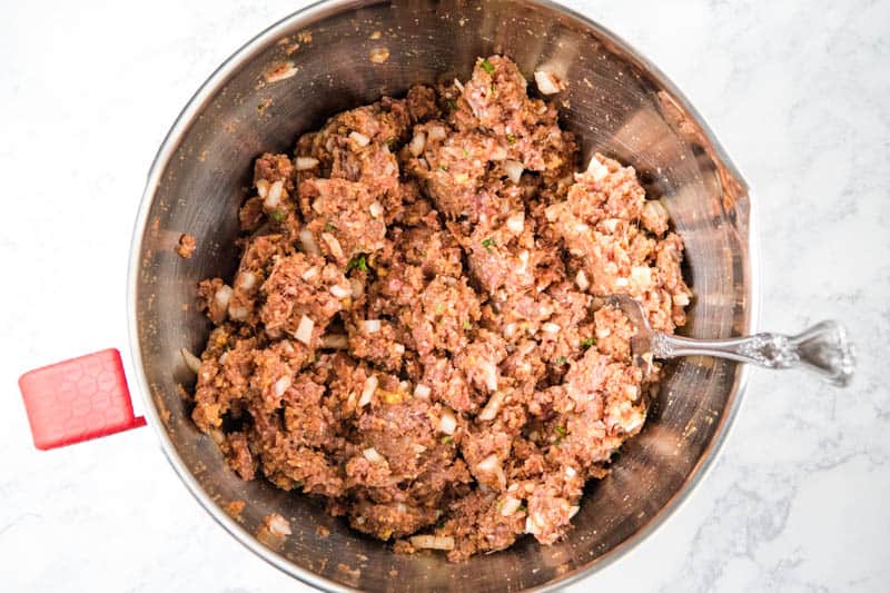 classic meatloaf mixture in metal mixing bowl with fork