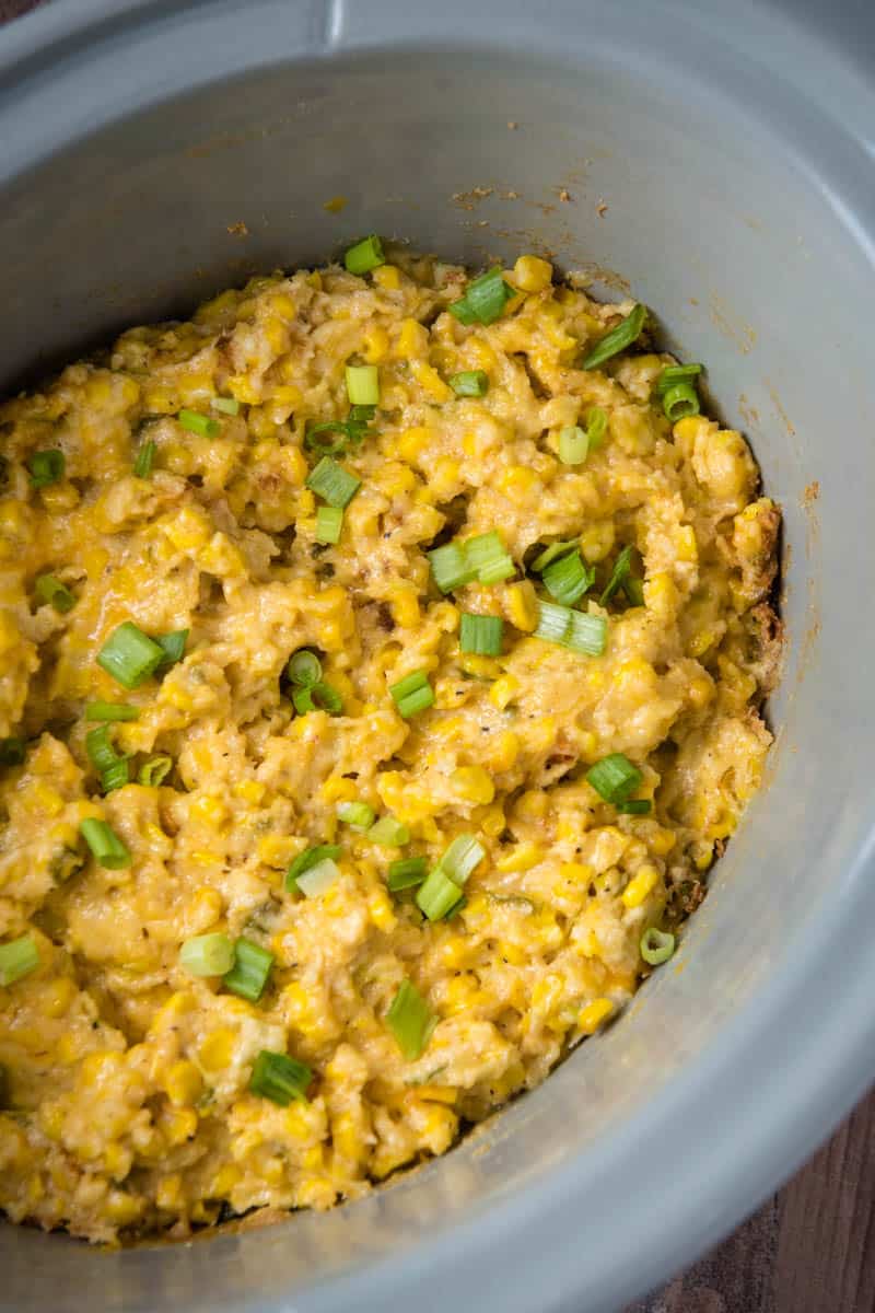 CrockPot corn casserole with cream cheese baked in gray slow cooker