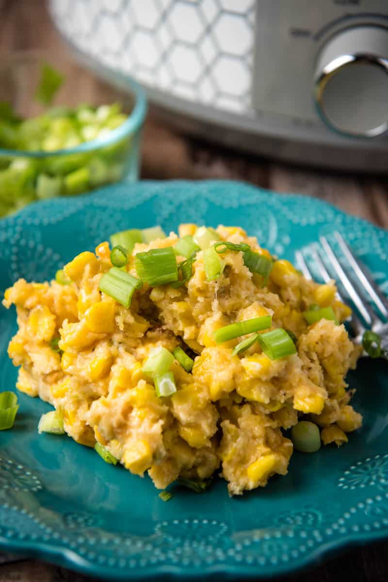 serving of Jiffy CrockPot corn casserole on teal plate with fork