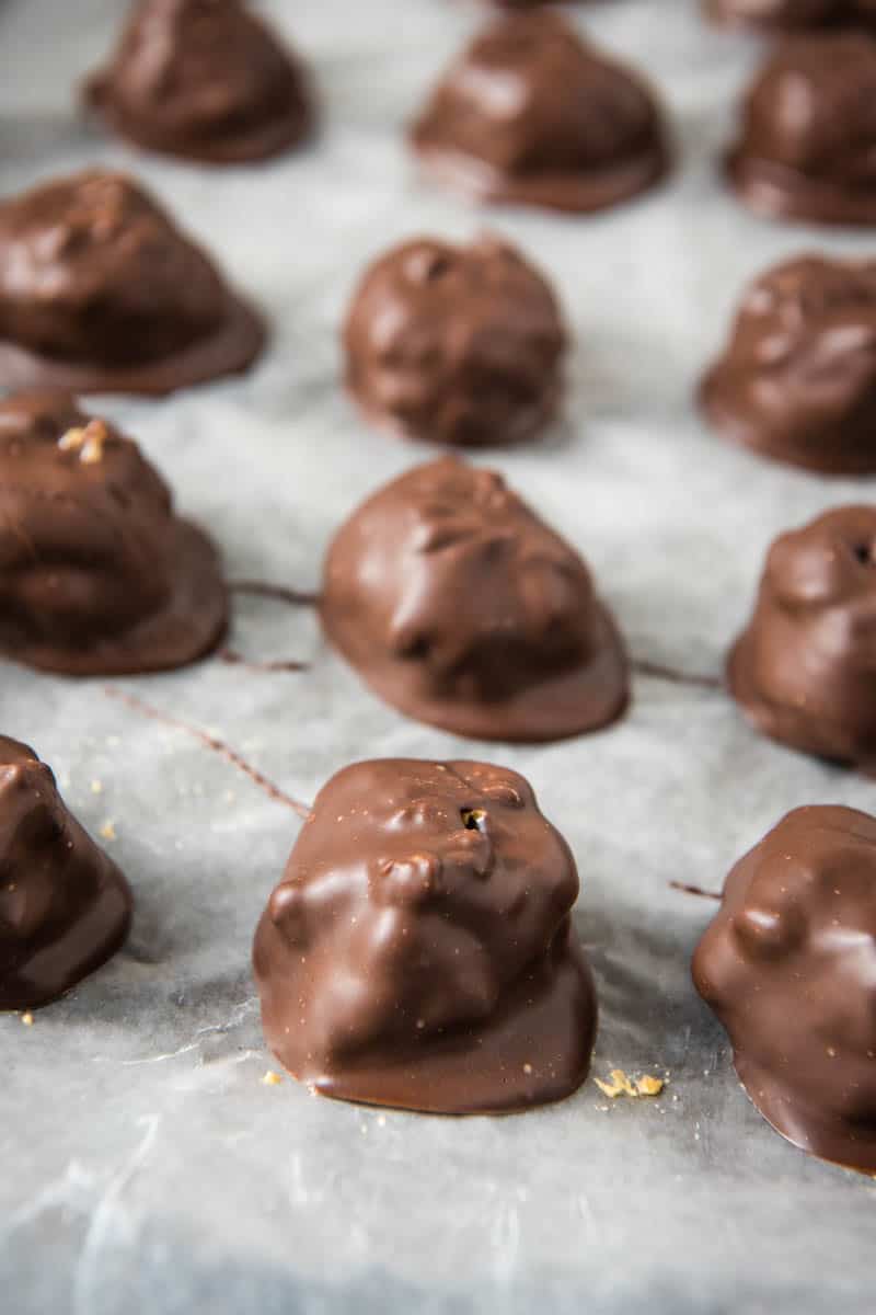chocolate covered Rice Krispie peanut butter balls on wax paper lined baking sheet