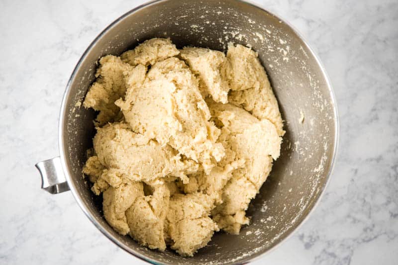 sugar cookie dough mixed up in large silver mixing bowl